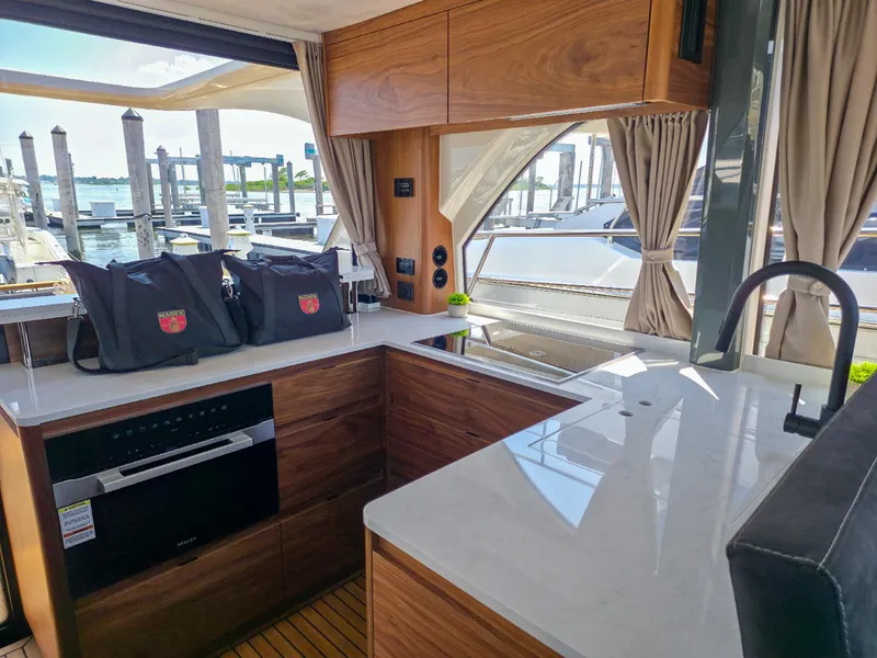 Slide: The Image of Luxurious Marex 440 yacht interior with modern kitchen, wood cabinetry, and marina view, 2026 model. - 40