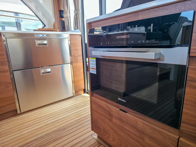 Slide: The Image of Modern kitchen interior on 2026 Marex 440 yacht, featuring stainless steel appliances and wood flooring. - 43