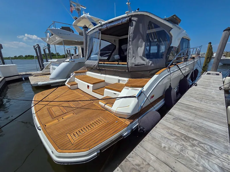 Slide: The Image of 2026 Marex 440 yacht docked, featuring sleek design and wooden deck. - 10