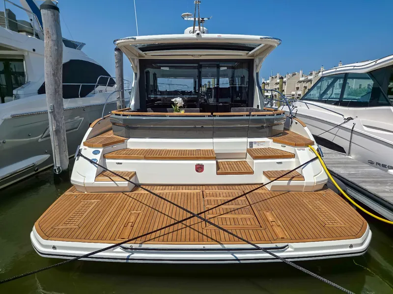 Slide: The Image of 2026 Marex 440 yacht docked, featuring elegant wooden deck and modern design. - 14