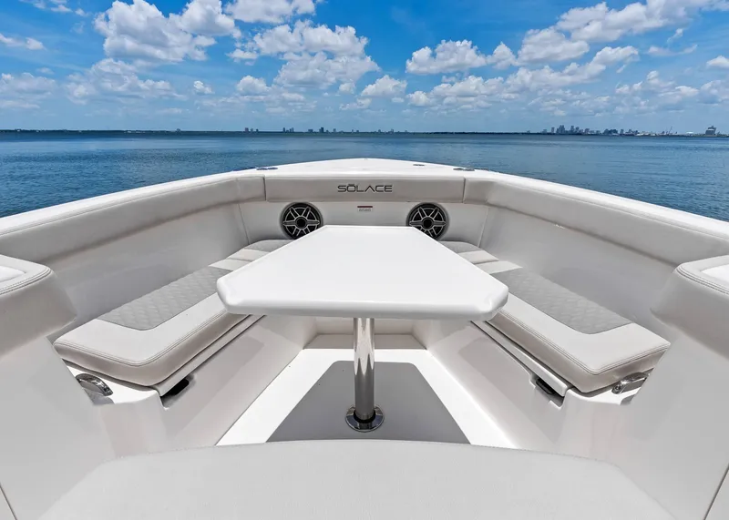 Slide: The Image of 2025 Solace 32 CS boat interior with seating and table, ocean view. - 13