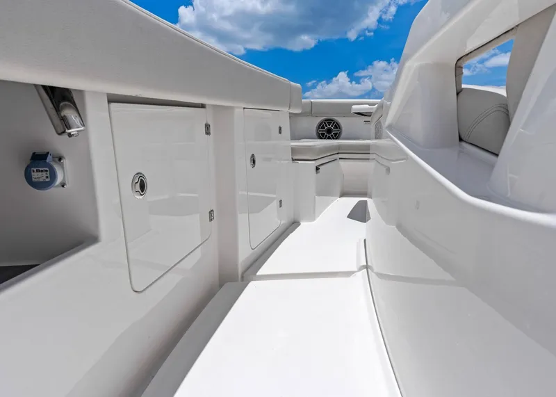 Slide: The Image of 2025 Solace 32 CS boat interior with sleek white design and storage compartments. - 16