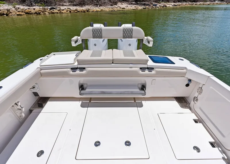 Slide: The Image of 2025 Solace 32 CS boat deck with seating, near calm green water. - 17