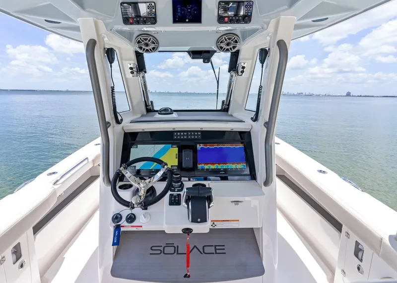 Slide: The Image of 2025 Solace 32 CS boat cockpit with advanced navigation system and ocean view. - 19