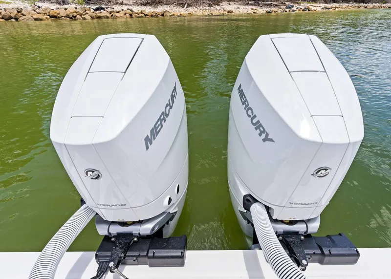 Slide: The Image of Twin Mercury outboard engines on a 2025 Solace 32 CS boat in green water. - 24