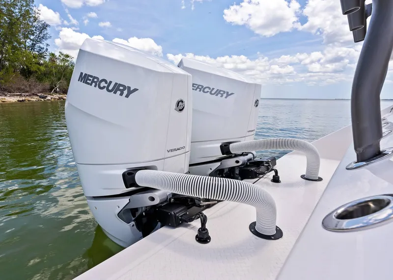 Slide: The Image of Twin Mercury Verado engines on a 2025 Solace 32 CS boat, docked by the shore. - 25