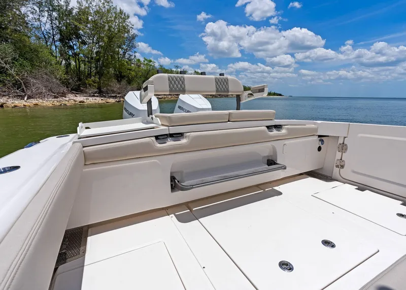 Slide: The Image of 2025 Solace 32 CS boat interior with seating, near shoreline under blue sky. - 26