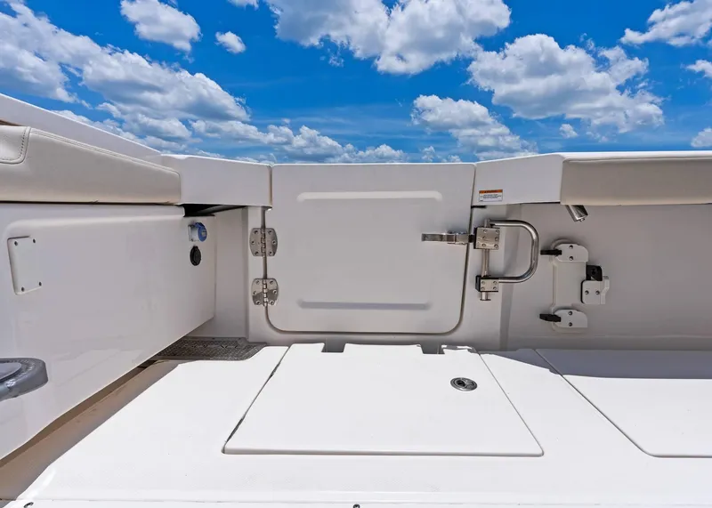 Slide: The Image of 2025 Solace 32 CS boat deck with storage compartments under a blue sky. - 31