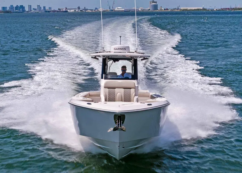 Slide: The Image of 2025 Solace 32 CS boat cruising on open water, city skyline in background. - 9