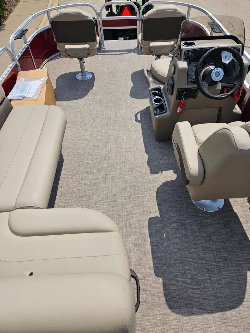 Slide: The Image of 2025 Bass Tracker BB16XLS boat interior with beige seating and steering console. - 2