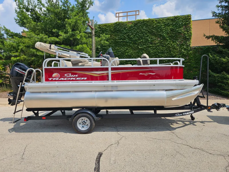 The Image of 2025 Bass Tracker BB16XLS pontoon boat on trailer, parked outdoors. - 0