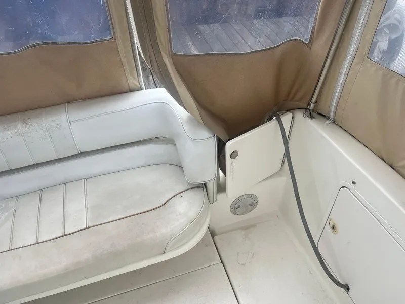 Slide: The Image of Interior of 1995 Sea Ray 250 Sundancer boat with white seating and tan canvas. - 12