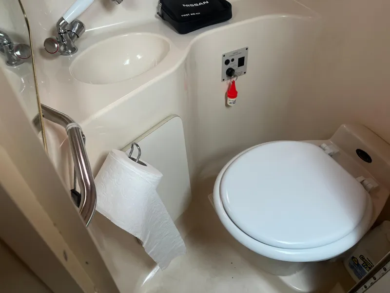 Slide: The Image of 1995 Sea Ray 250 Sundancer boat bathroom with toilet, sink, and toilet paper holder. - 14