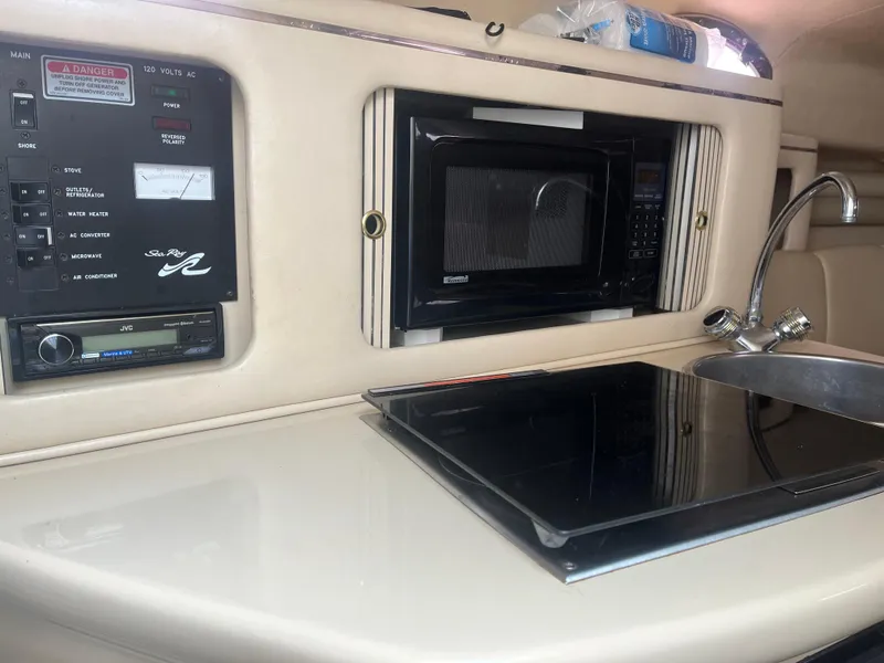 Slide: The Image of 1995 Sea Ray 250 Sundancer galley with microwave, sink, and control panel. - 17