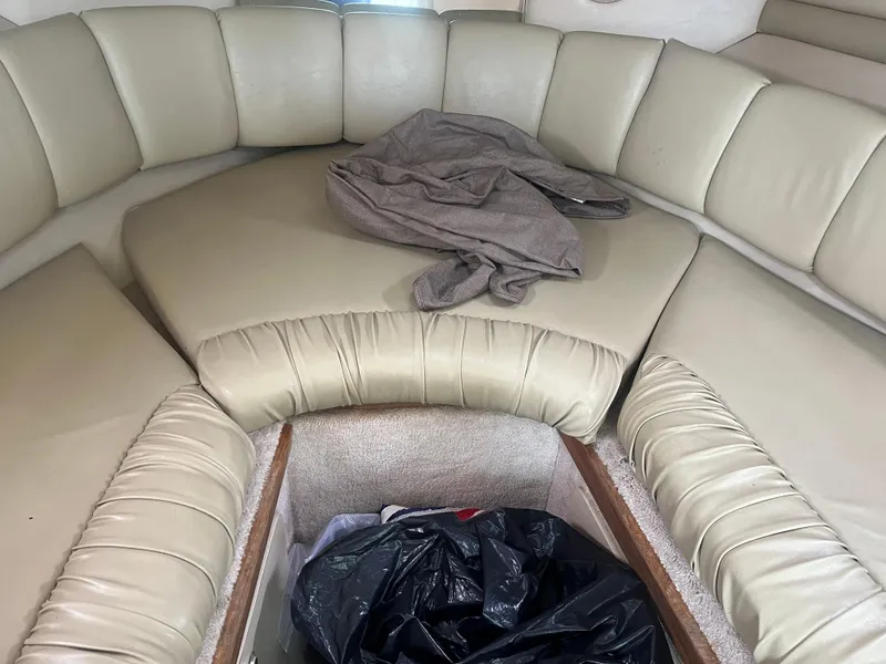Slide: The Image of 1995 Sea Ray 250 Sundancer cabin interior with beige seating and storage compartment. - 21