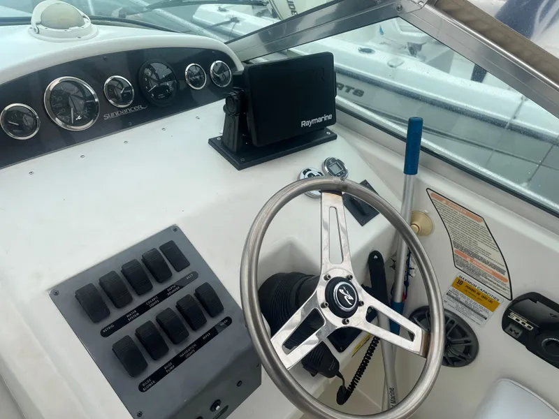 Slide: The Image of 1995 Sea Ray 250 Sundancer helm with steering wheel and control panel. - 23
