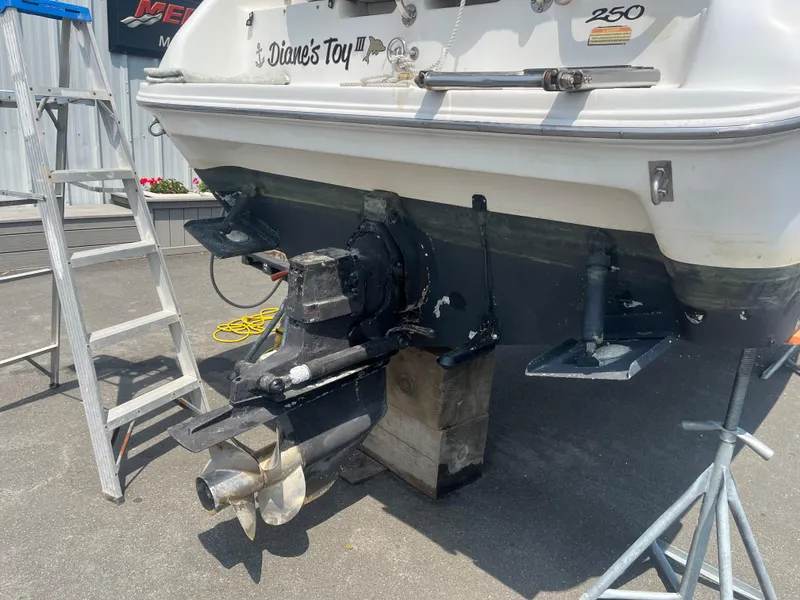 Slide: The Image of 1995 Sea Ray 250 Sundancer boat on stands, showing stern and propeller. - 27