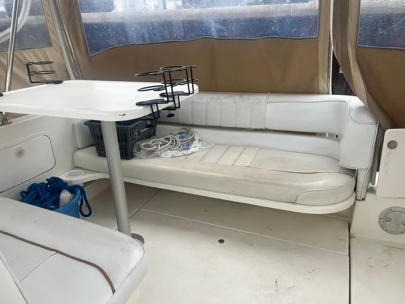 Slide: The Image of Interior of 1995 Sea Ray 250 Sundancer with white seating and table. - 33