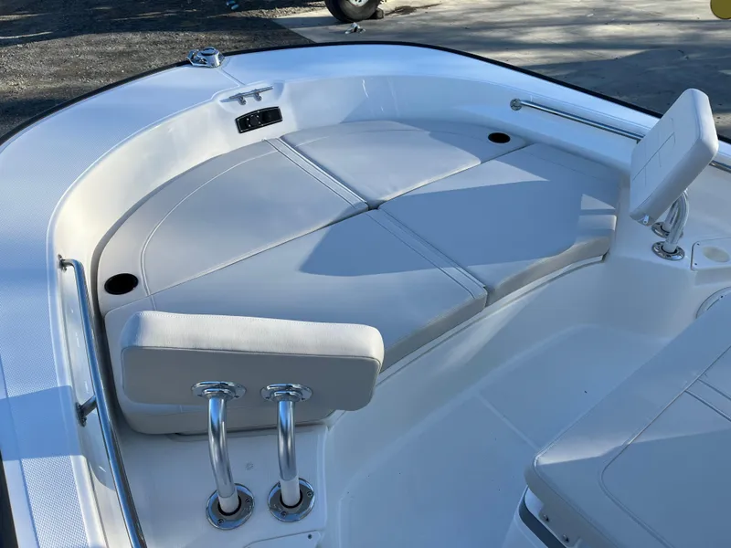 Slide: The Image of 2025 Boston Whaler 210 Montauk boat interior with cushioned seating and stainless steel fixtures. - 14