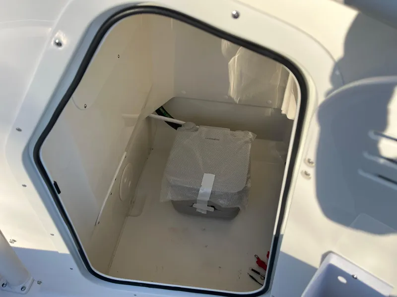 Slide: The Image of Storage compartment in 2025 Boston Whaler 210 Montauk boat, featuring a secured package. - 6