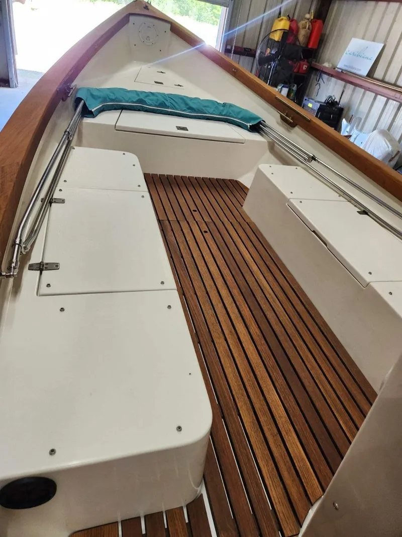 Slide: The Image of 2005 Caribiana Skiff boat interior with wooden deck and white seating. - 11