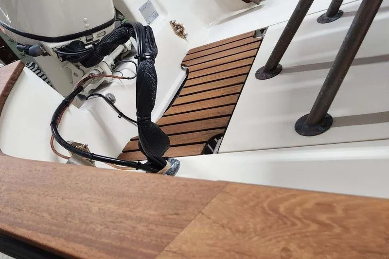 Slide: The Image of 2005 Caribiana Skiff boat interior with wooden deck and motor details. - 13
