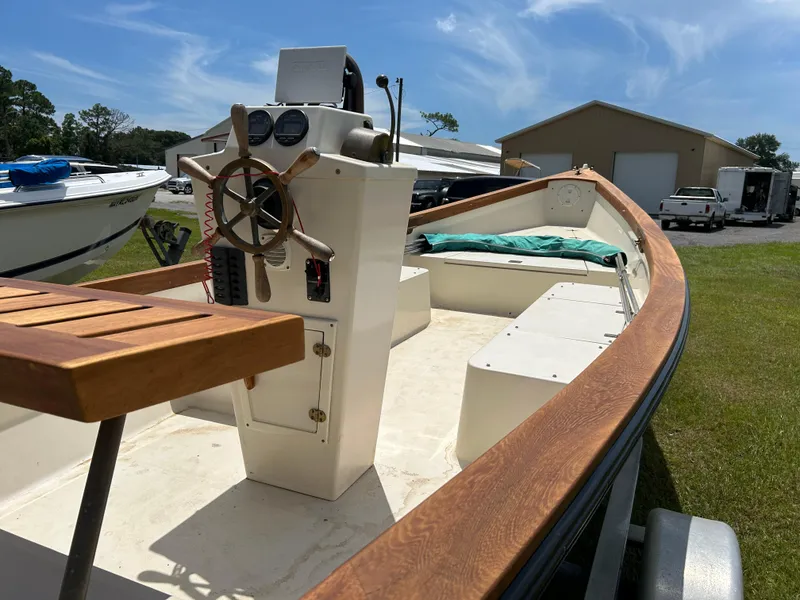 Slide: The Image of 2005 Caribiana Skiff boat with wooden accents and steering wheel, parked outdoors. - 4