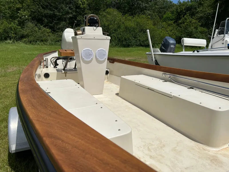 Slide: The Image of 2005 Caribiana Skiff boat with wooden trim, parked on grass, surrounded by trees. - 6
