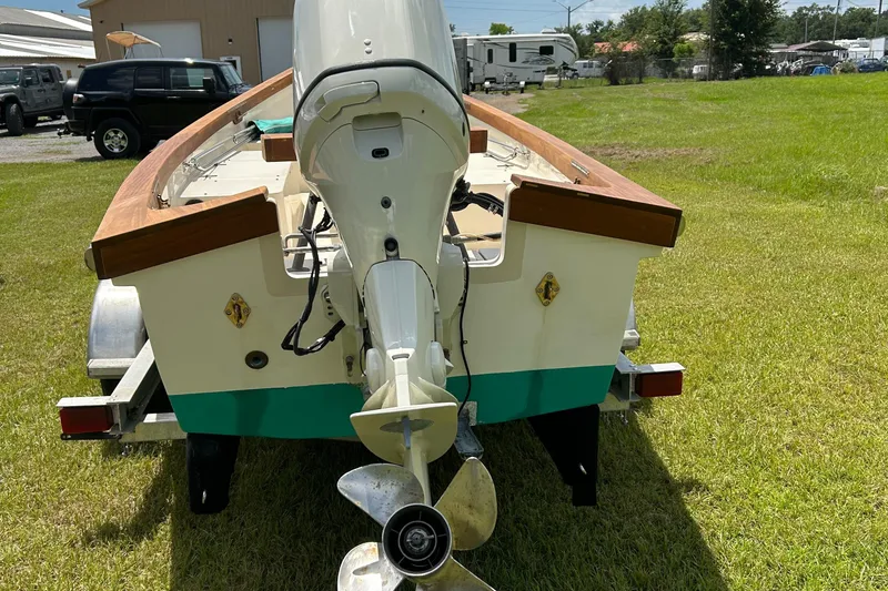 Slide: The Image of 2005 Caribiana Skiff boat on trailer, rear view, parked on grass. - 8