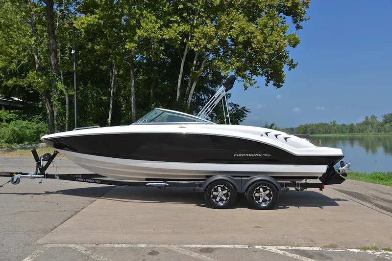 Slide: The Image of 2019 Chaparral 23 H20 boat on trailer by a lake, surrounded by trees. - 11