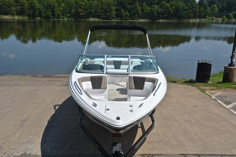 Slide: The Image of 2019 Chaparral 23 H20 boat on trailer by a serene lake. - 17