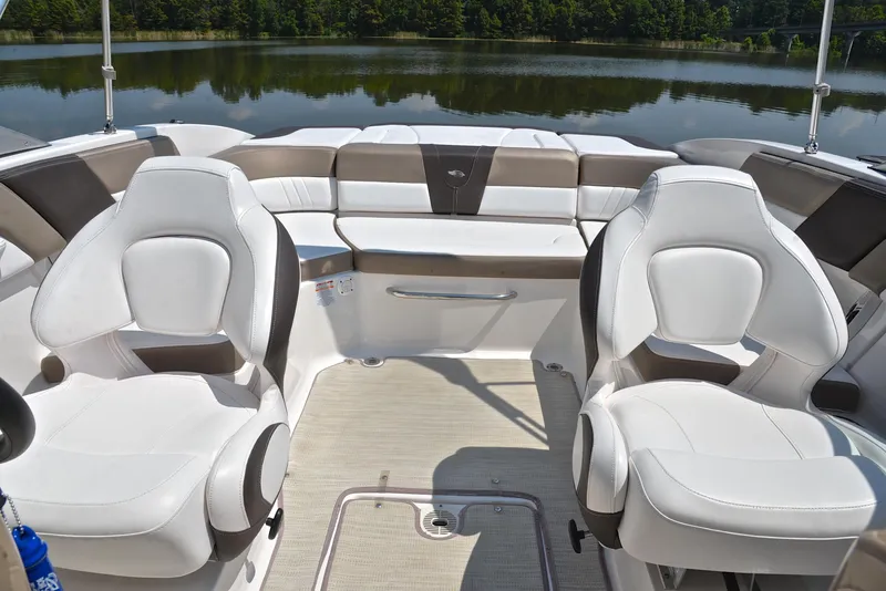 Slide: The Image of 2019 Chaparral 23 H20 boat interior with white seating, on a calm lake. - 22