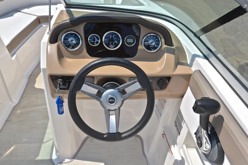 Slide: The Image of 2019 Chaparral 23 H20 boat dashboard with steering wheel and instrument panel. - 25