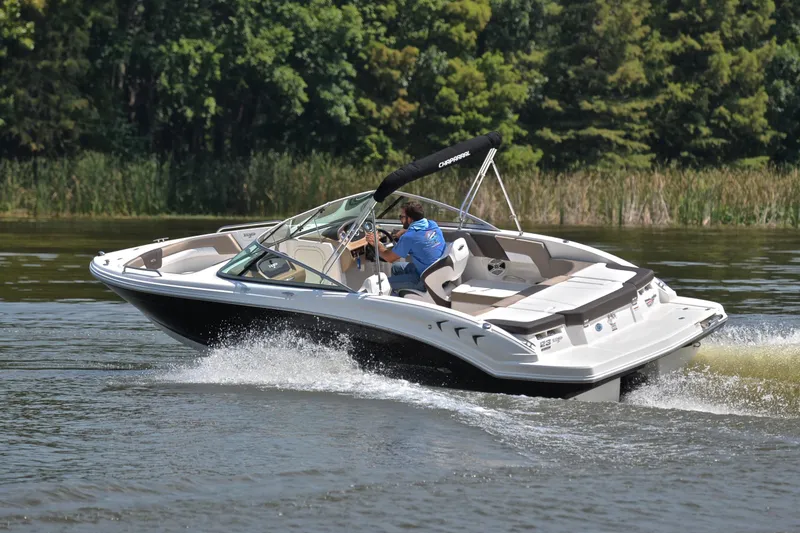 Slide: The Image of 2019 Chaparral 23 H20 speedboat cruising on a lake with lush greenery. - 6