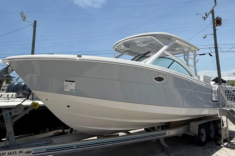 The Image of 2024 Robalo R317 Dual Console boat on trailer, side view, under clear sky. - 0