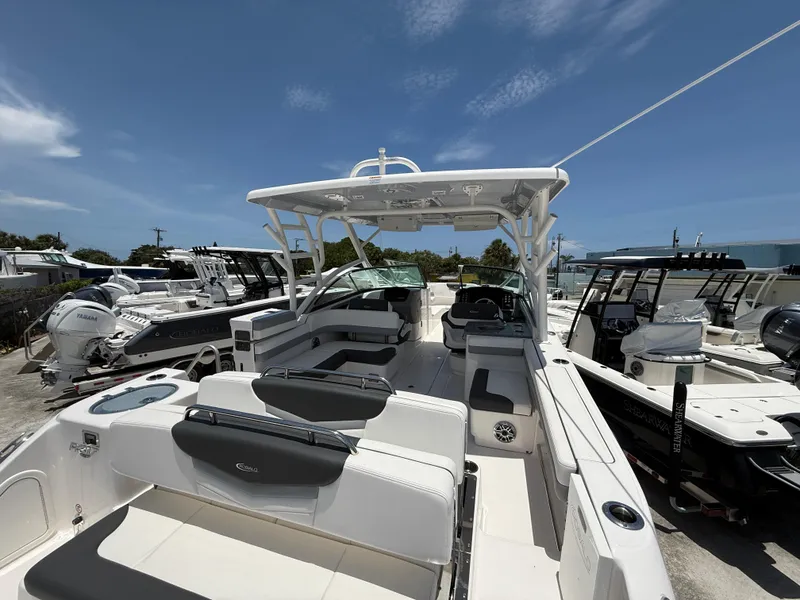 Slide: The Image of 2024 Robalo R317 Dual Console boat with spacious seating and modern design, docked under clear skies. - 10