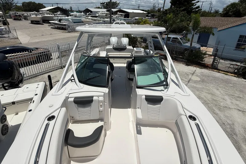 Slide: The Image of 2024 Robalo R317 Dual Console boat with spacious seating and sleek design in a marina setting. - 17
