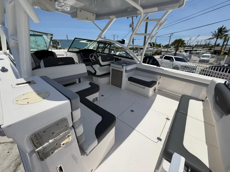 Slide: The Image of 2024 Robalo R317 Dual Console boat interior with seating and helm, docked outdoors. - 8