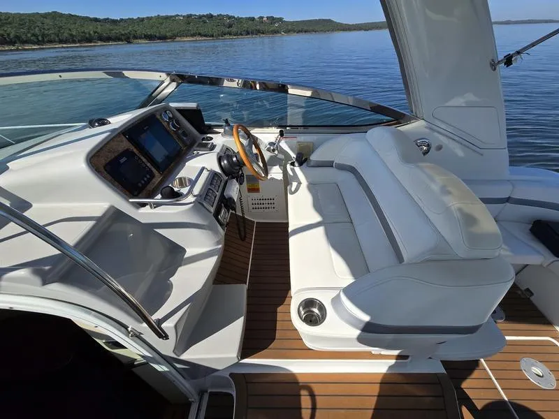 Slide: The Image of 2008 Formula 37 PC yacht cockpit with modern controls and seating on a serene lake. - 25