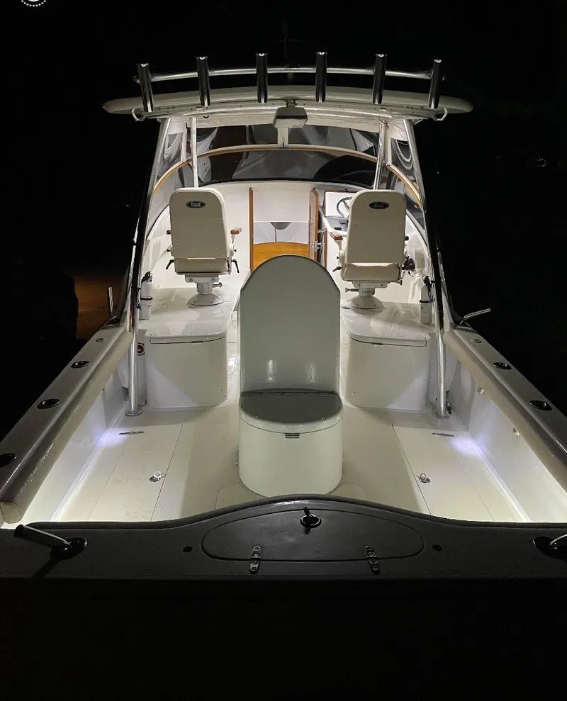 Slide: The Image of 2011 Custom Carolina Express boat with illuminated deck and seating at night. - 3