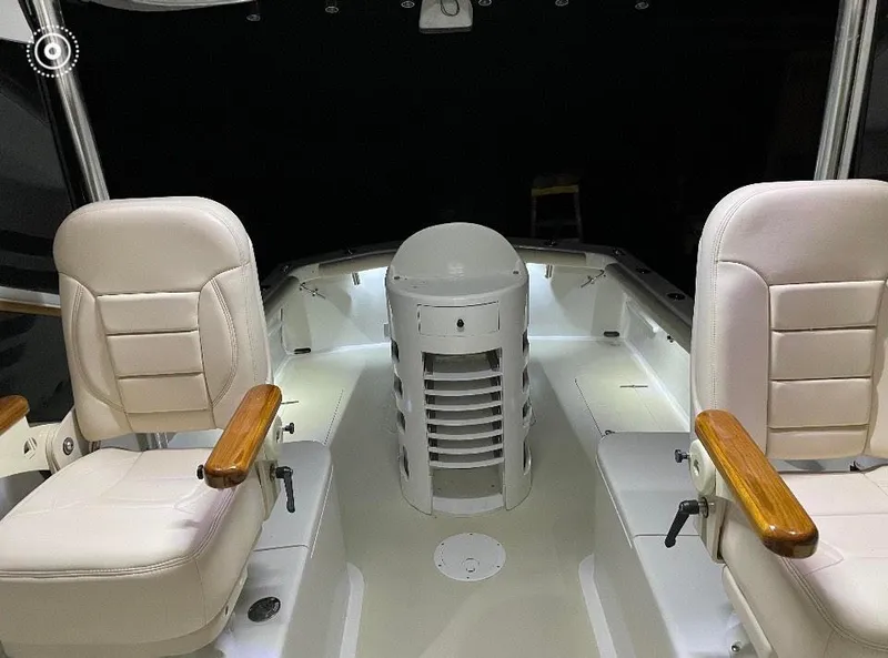 Slide: The Image of 2011 Custom Carolina Express boat interior with white seating and wooden armrests. - 4