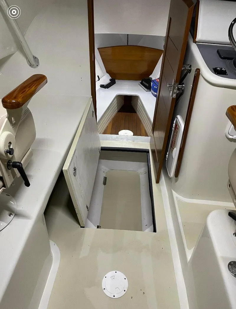 Slide: The Image of 2011 Custom Carolina Express boat interior with cabin access and wooden accents. - 8