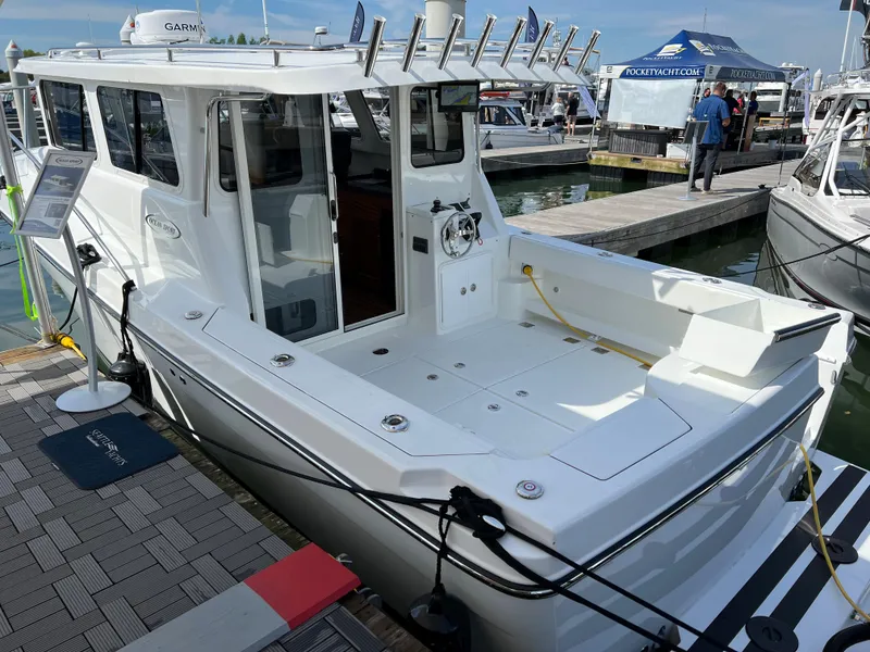 Slide: The Image of Ocean Sport 30 Roamer 2022 docked, showcasing spacious deck and modern design. - 16