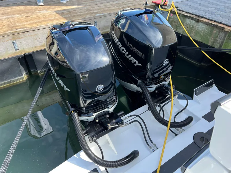 Slide: The Image of Twin Mercury outboard engines on a 2022 Ocean Sport 30 Roamer boat at a dock. - 17