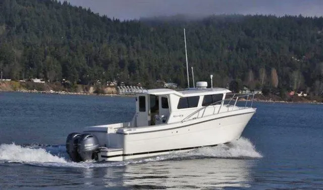 Slide: The Image of 2022 Ocean Sport 30 Roamer cruising on a scenic lake with forested hills. - 5