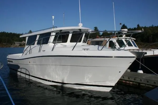 Slide: The Image of 2022 Ocean Sport 30 Roamer boat docked on calm water. - 6