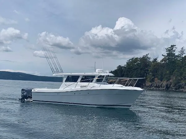 Slide: The Image of 2022 Ocean Sport 30 Roamer boat on calm water with cloudy sky backdrop. - 7