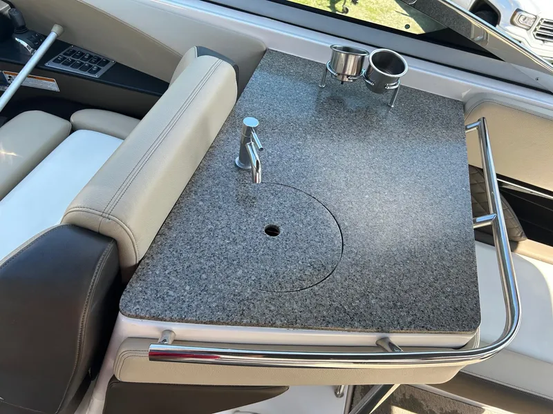 Slide: The Image of 2013 Regal 3200 Bowrider interior with granite countertop and cup holders. - 12