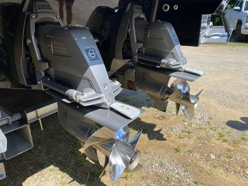 Slide: The Image of 2013 Regal 3200 Bowrider with Volvo Penta outdrives, parked on gravel. - 5