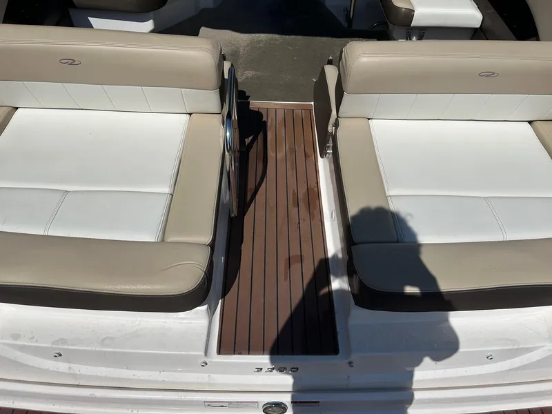 Slide: The Image of 2013 Regal 3200 Bowrider boat interior with beige seating and wooden flooring. - 9